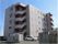 施設外観。５階建てでベージュを基調とした建物