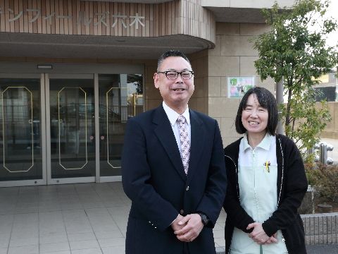 施設の前に立ち微笑むスタッフさん。
