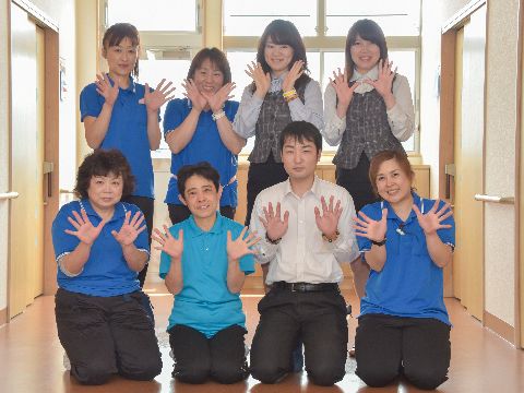 施設のスタッフ紹介。シャツにベストの女性職員や、青いポロシャツに黒のボトムが制服のスタッフ、Yシャツにスーツの職員。