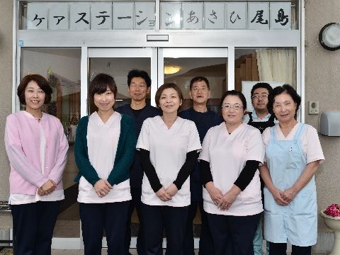 玄関前に並ぶ女性5名、男性3名のスタッフの皆さんである。ご入居様の日々の様々な介助、自立支援を行っている。