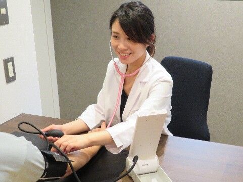 看護師が男性の血圧を測っている様子