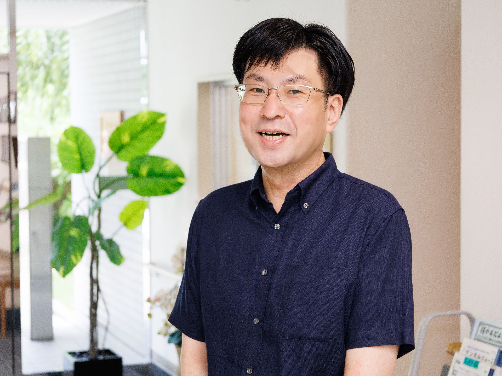 笑顔で立っている眼鏡をかけた男性従業員