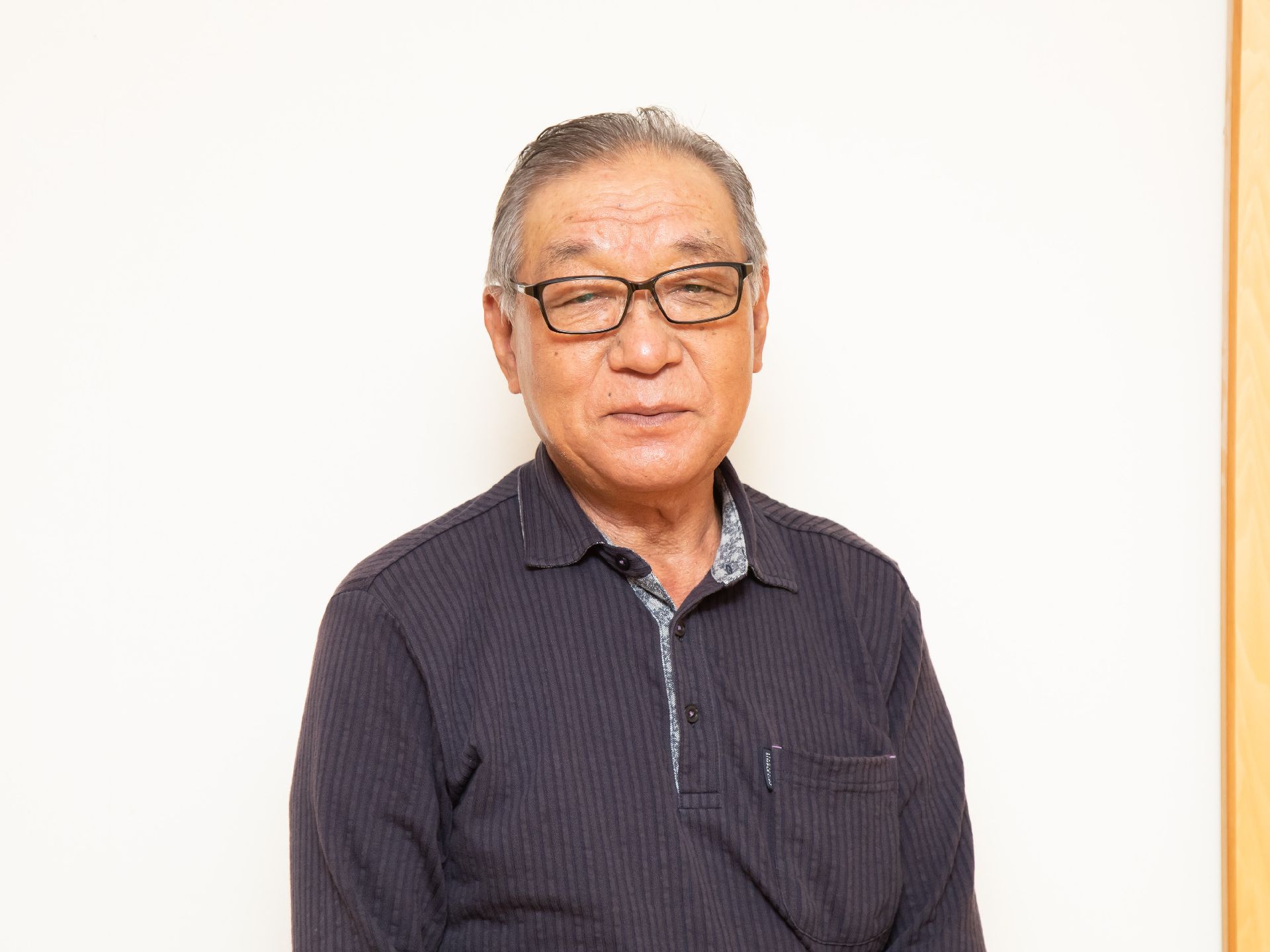 白い壁の前に立っている男性従業員