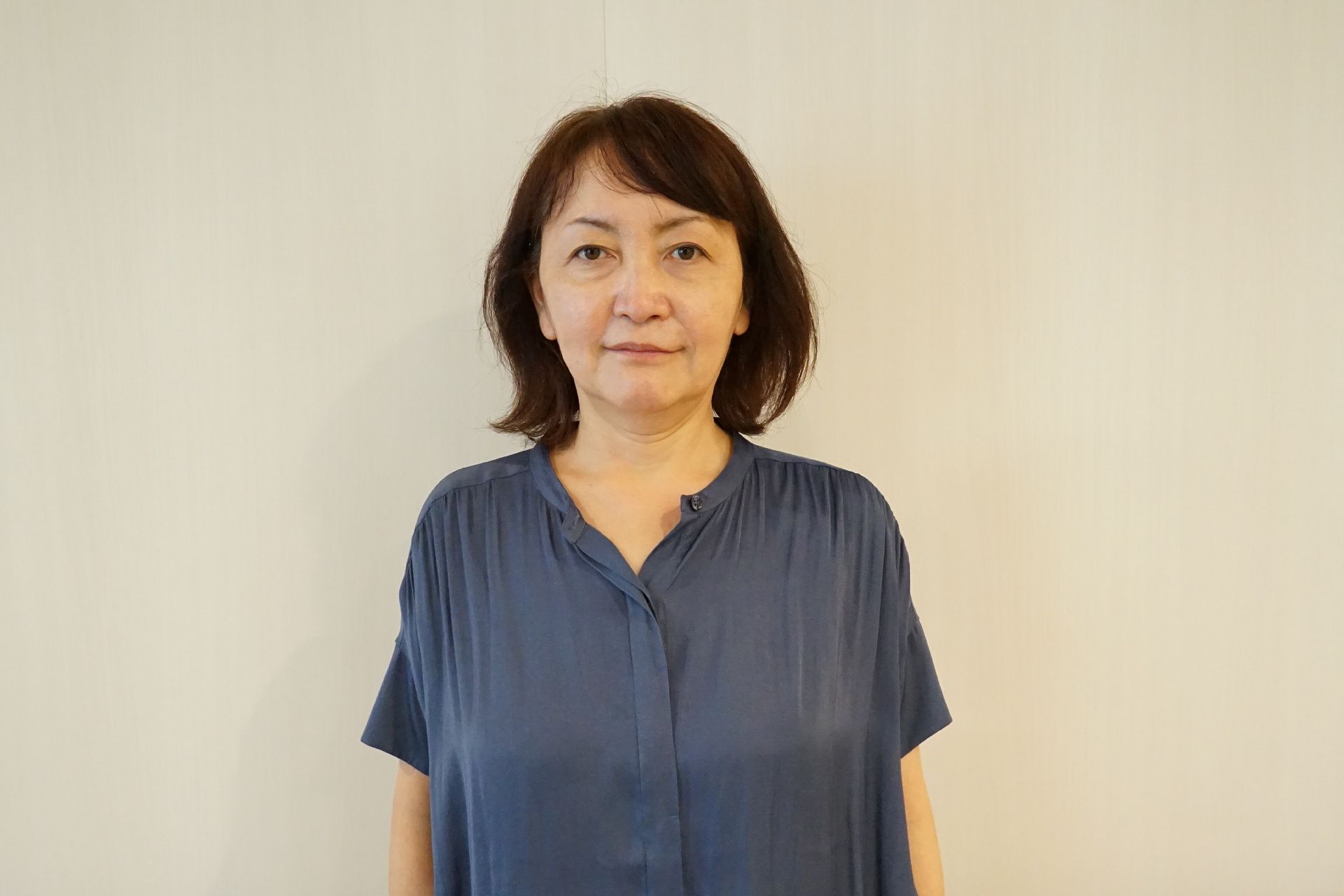 白い壁の前に立っている女性従業員