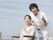 車椅子に乗った女性と看護師が外で景色を眺めている様子