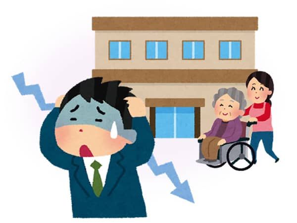 介護施設の前で頭を抱えて悩む男性職員