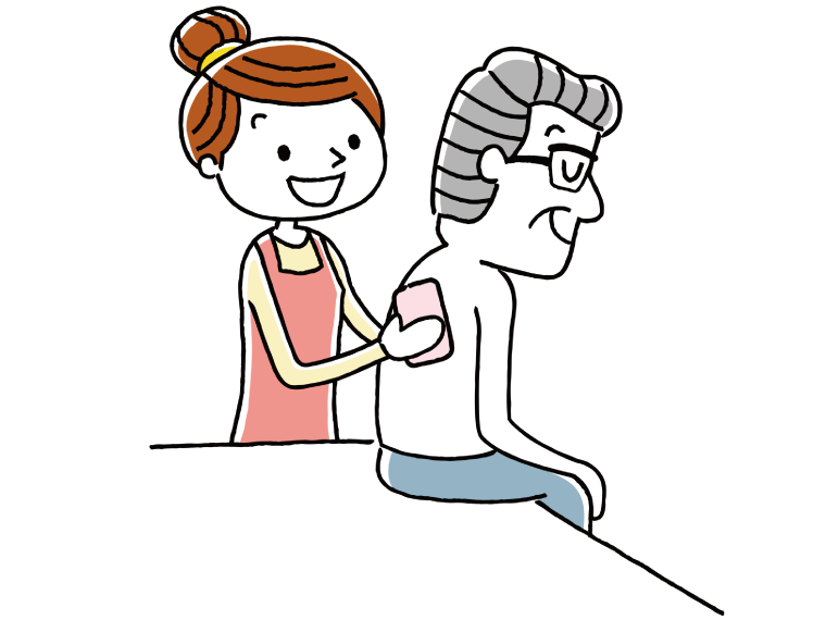高齢男性の背中を拭くエプロンを付けた女性