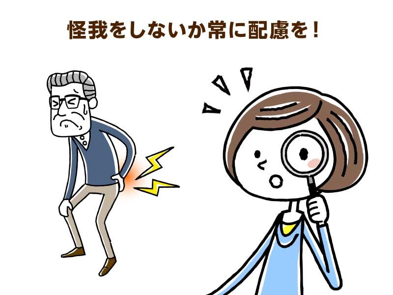 腰を痛めている様子の高齢男性と虫眼鏡を持った若い女性