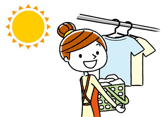 太陽の下で洗濯物を持っているエプロンをした若い女性