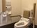 背もたれや手すりが設置されたトイレの壁にはカラフルな操作パネルが付いている。