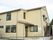 ベージュの２階建ての建物はバリアフリー設計。玄関には屋根が付いている。