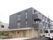3階建ての建物はコンクリート製でどっしりとした頑丈な建物。2階と3階はグレー1階はベージュ。