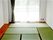畳敷きの部屋には大きな窓が付き、レースカーテンとカーテンが付いている。