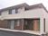 ２階建て住宅のような質感の施設外観。右側にバリアフリーのエントランス