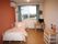 ひとりで部屋でくつろいでいる男性。ホワイトを基調とした部屋で明るい様子が分かる