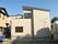 ベージュの外壁はレンガ調。２階建ての住宅は一般の住宅のような外観。