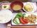 肉のいためたものには生野菜が添えられ、みそ汁や白いご飯、フルーツなどがある。