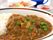 カレーライスが写っている写真。奥のほうに飲み物やおかず類が写っている