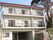 3階建ての建物は白を基調としていて、ベランダが各フロアにつき、周辺には自然も残されている。