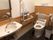 手すりと洗面台がある施設の介護仕様のトイレの様子。オールバリアフリーの床
