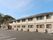 ２階建ての建物は横に長く、日当たりのいい場所に建っていて、玄関には屋根が付いている。
