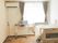 エアコン付きのフローリングの部屋にはベッドがあり、ベッドサイドには緊急通報装置がある。