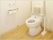 トイレの両サイドに可動式の手すりが付き、背もたれもある。介助用のスペースがとても広い。