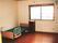 介護用ベッドや物置が置いてある小さなワンルームタイプの部屋。奥のほうに窓があり外につながっている