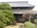立派な木が植えられた日本庭園の後ろには二階建ての日本家屋が見える。