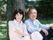2人でゆったりとほほ笑む老夫婦。外に出て自然を眺めている様子が分かる