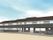 グレーでまとめられた2階建ての建物は横に長く、周辺にフェンスが建てられている。