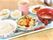 飲み物・ごはん・おかず・吸い物などがトレーに置かれているメニューの一例