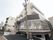 3階建ての建物は白をメインとしていて、1階部分はグレー。1階部分はガラス張りとなっていて、2階以上のフロアにはベランダが付いている。