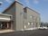 2階建ての建物の玄関部分には段差がなく、自動ドアで出入りもスムーズ。赤いいすも置かれている。