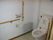 L字型の手すりが付いたトイレの様子。高齢者用の設備が見えている