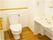 フローリングの広いトイレには手すりや手洗い場が付いている。