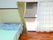 フローリングの部屋にはエアコンが付き、時計が設置されている。寝具付きのベッドもある。