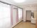 エアコンを挟んで２か所に窓がある広めの居住空間。奥のほうにトイレと洗面台がある様子