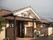 瓦屋根の平屋建ての建物は一般の家庭のような雰囲気。玄関先にはベンチがある。