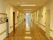 施設内の各部屋が並んだ通路である。明るく開放的な印象がある。広さも兼ねており接触事故なども少ないように感じる。