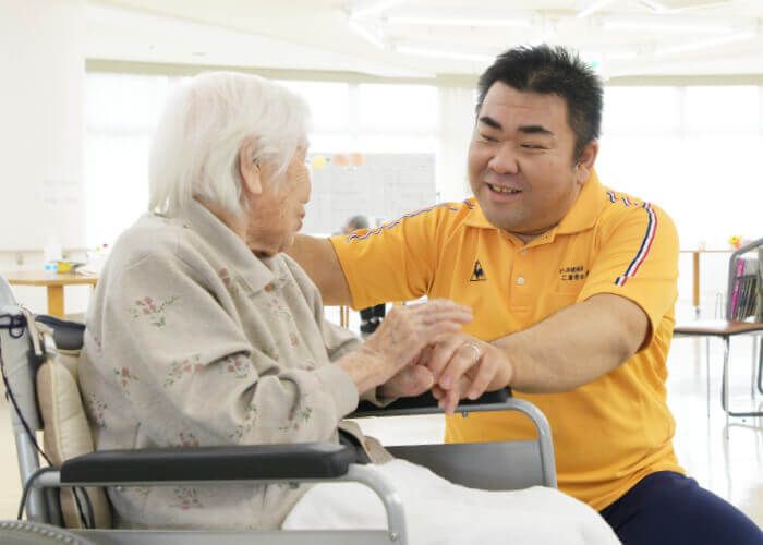 笑顔で手をつなぐスタッフと利用者