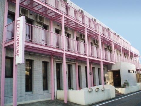 ライフコミューン市ヶ尾の外観。ピンクのポールが特徴的な施設外観。車いす用のスロープがついております。