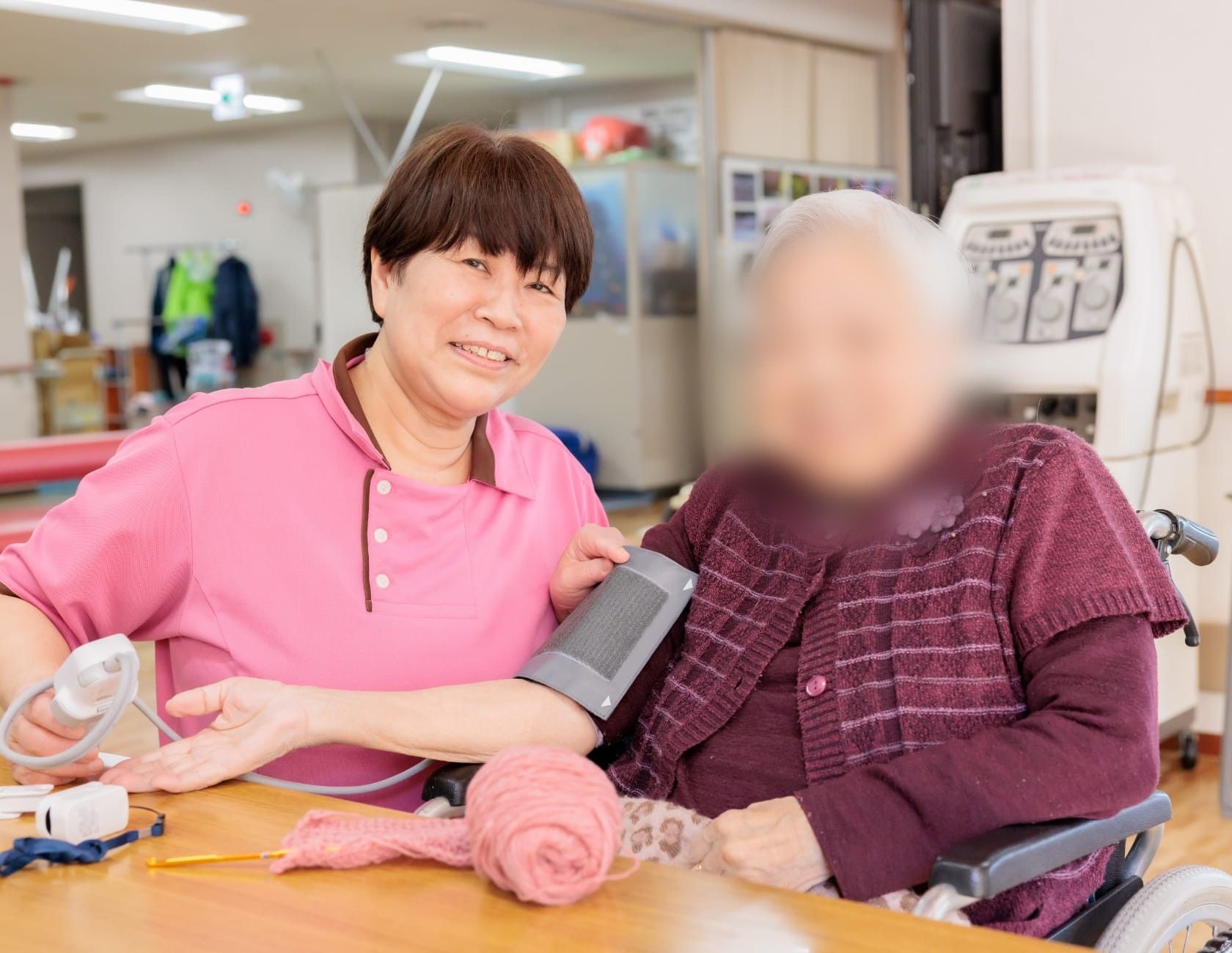 笑顔で血圧測定するスタッフ