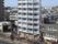 周囲を他の建物で囲まれた場所に建つ、高層建築の施設外観