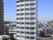 白い外壁を持ち、十二階建てという高さがある施設建物の遠景