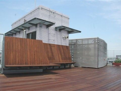 焦げ茶色の木製デッキが広がり、座るスペースもある施設の屋上