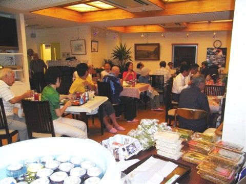 アルコールなどのドリンクや、焼きそばなどの軽食を楽しみながら談笑している入居者たち