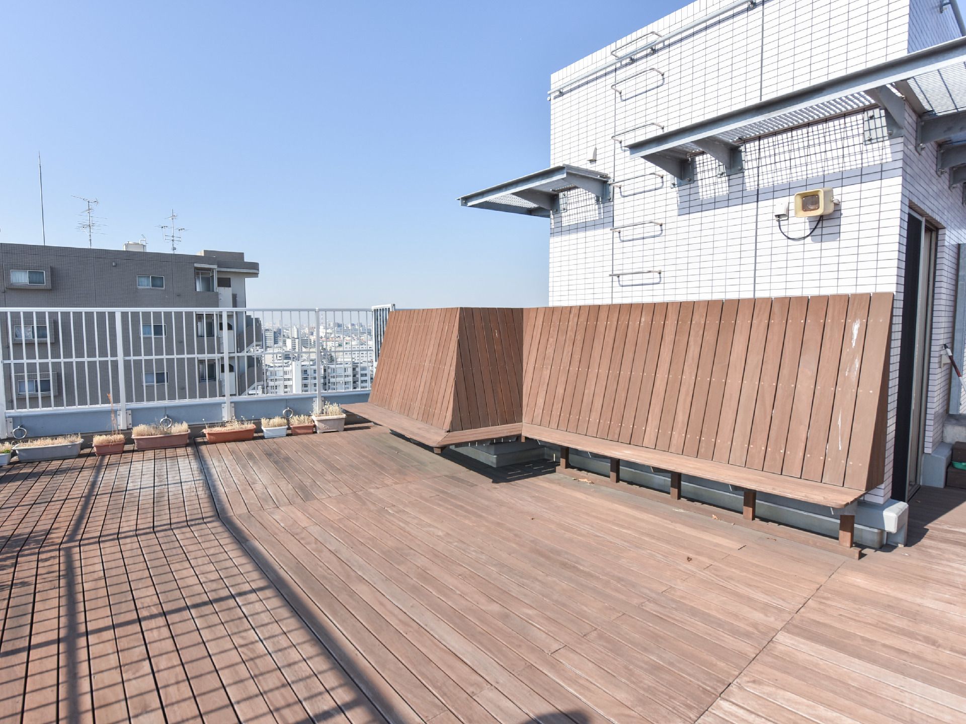 屋上の床は木の板が敷き詰められていて歩きやすい。端には床に合わせたデザインの木製ベンチが設置されている。