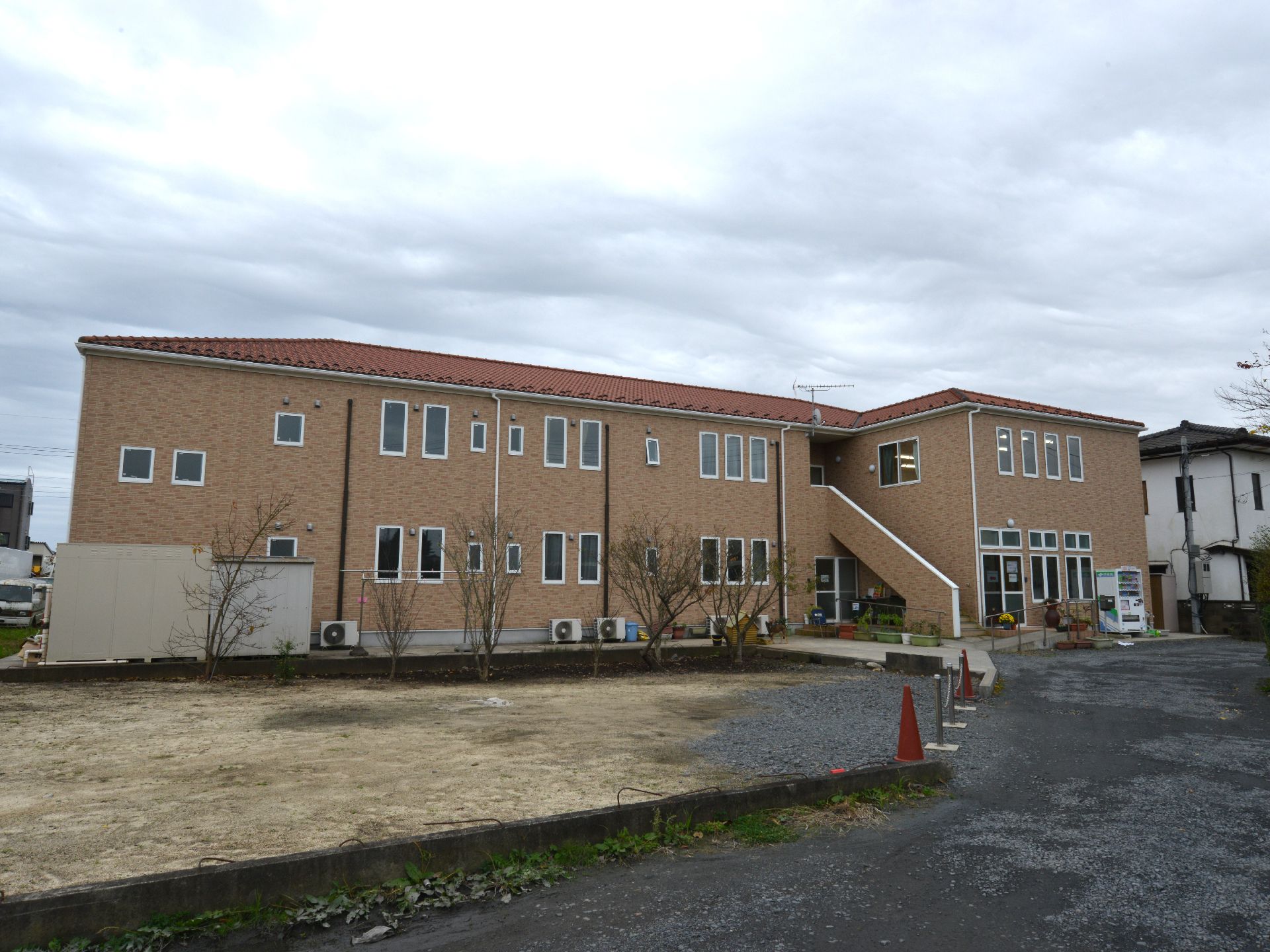 閑静な住宅地に建てられている施設はレンガ調の外壁が洋館のような雰囲気がある。道路から入り口までは段差のない坂道になっている。