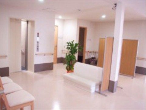 白色のベンチや椅子が置かれている、エレベーター乗降口付近